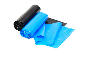 Image showing roll of blue and  black garbage bags on a white background 