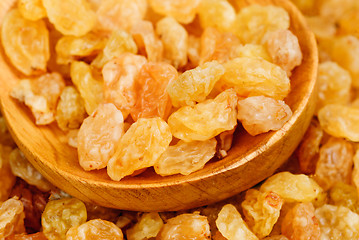 Image showing Golden raisins close- up and wooden spoon, food background 