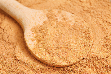 Image showing Cinnamon  powder and wooden spoon as  nature  food   background