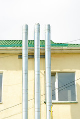 Image showing Three chimney smoke on  building background