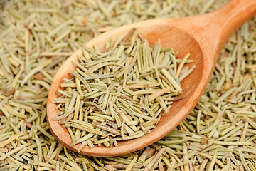 Image showing rosemary in wooden spoon and over as background 