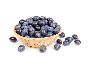 Image showing fresh blue plums in fruit basket on the white background  