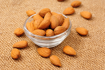 Image showing Dried almonds on glass bowl on canvas background 
