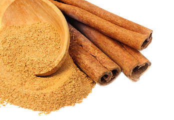 Image showing Cinnamon -  sticks and powder  and  wooden spoon  isolated  on  white