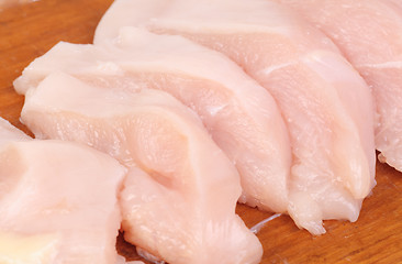 Image showing chicken meat sliced   on  cutting  board isolated  on  white  background