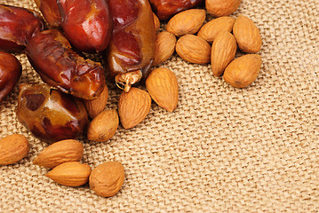 Image showing dried dates and almonds on canvas background