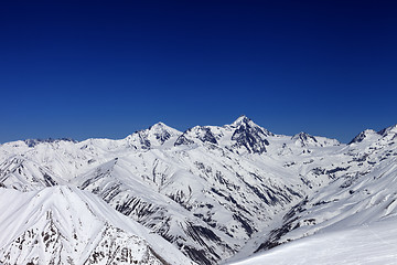 Image showing View on off-piste slope, winter snowy mountains and blue clear s