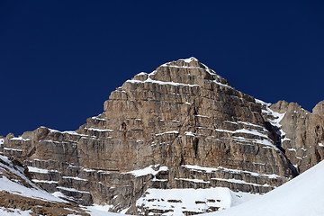 Image showing Rocks in snow and blue clear sky