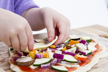 Image showing small hands preparing pizza