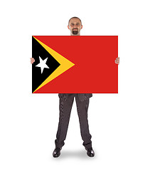 Image showing Smiling businessman holding a big card or flag