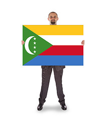 Image showing Smiling businessman holding a big card or flag