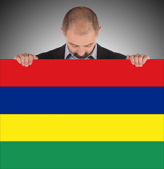 Image showing Smiling businessman holding a big card or flag