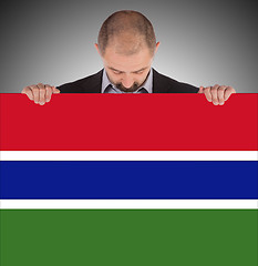 Image showing Smiling businessman holding a big card or flag