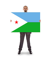 Image showing Smiling businessman holding a big card or flag