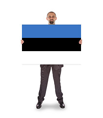 Image showing Smiling businessman holding a big card or flag