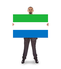 Image showing Smiling businessman holding a big card or flag