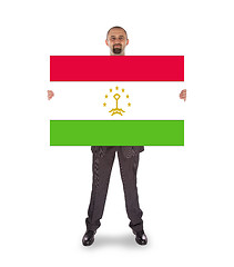 Image showing Smiling businessman holding a big card or flag