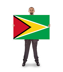 Image showing Smiling businessman holding a big card or flag