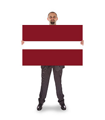 Image showing Smiling businessman holding a big card or flag