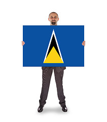 Image showing Smiling businessman holding a big card or flag