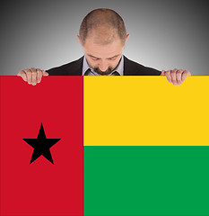 Image showing Smiling businessman holding a big card or flag