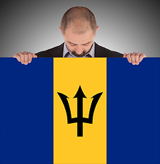 Image showing Smiling businessman holding a big card or flag