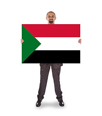 Image showing Smiling businessman holding a big card or flag