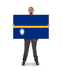 Image showing Smiling businessman holding a big card or flag