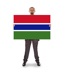 Image showing Smiling businessman holding a big card or flag