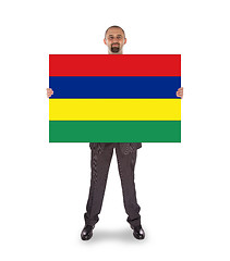 Image showing Smiling businessman holding a big card or flag