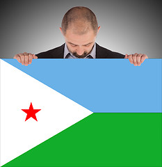 Image showing Smiling businessman holding a big card or flag