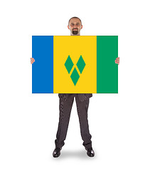 Image showing Smiling businessman holding a big card or flag