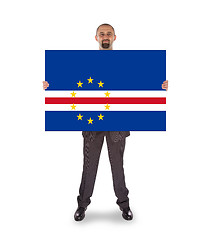 Image showing Smiling businessman holding a big card or flag