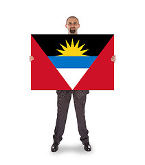 Image showing Smiling businessman holding a big card or flag