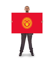 Image showing Smiling businessman holding a big card or flag