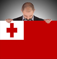 Image showing Smiling businessman holding a big card or flag