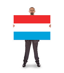 Image showing Smiling businessman holding a big card or flag