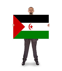 Image showing Smiling businessman holding a big card or flag