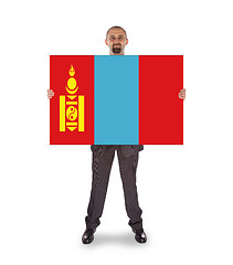 Image showing Smiling businessman holding a big card or flag