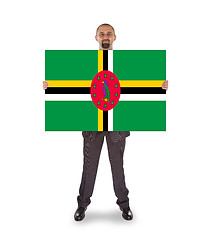 Image showing Smiling businessman holding a big card or flag