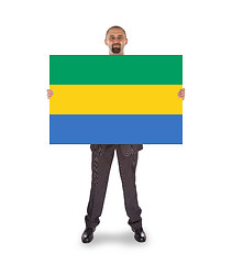 Image showing Smiling businessman holding a big card or flag