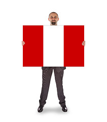 Image showing Smiling businessman holding a big card or flag