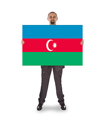 Image showing Smiling businessman holding a big card or flag