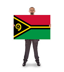 Image showing Smiling businessman holding a big card or flag