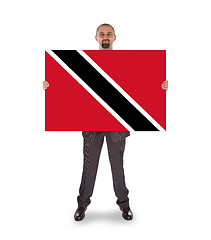 Image showing Smiling businessman holding a big card or flag