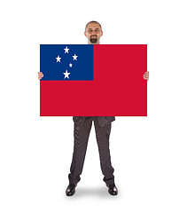 Image showing Smiling businessman holding a big card or flag