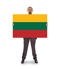 Image showing Smiling businessman holding a big card or flag