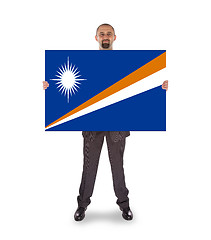 Image showing Smiling businessman holding a big card or flag