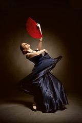 Image showing young woman dancing flamenco on black