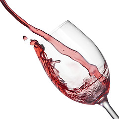 Image showing Splash of red wine in wineglass on white